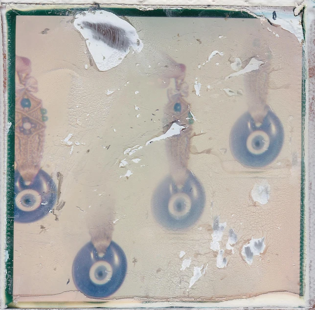 a couple of blue wheels sitting on top of a wall, an album cover, by Julian Schnabel, conceptual art, cast glass eyes, tiled, damaged webcam image, portholes