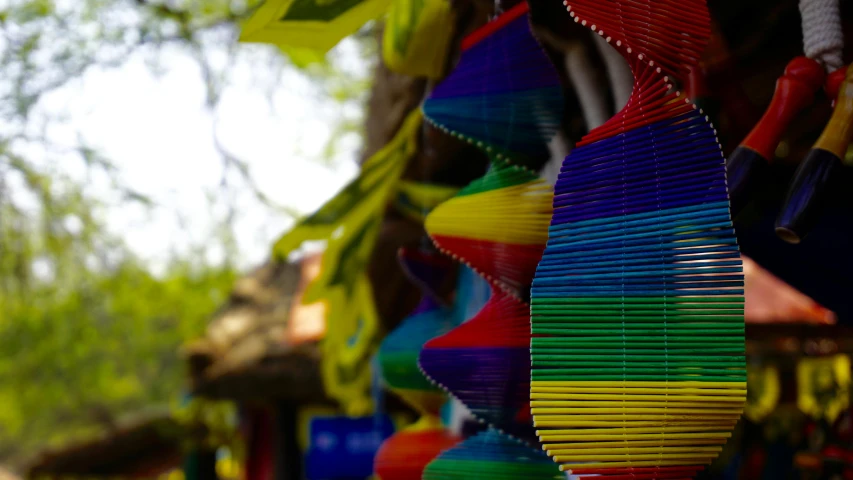 a bunch of colorful kites hanging from a tree, inspired by Nam Gye-u, pexels contest winner, colorful striped pavillions, sri lanka, tlaquepaque, shot on sony a 7 iii