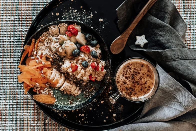 a black plate topped with oatmeal next to a cup of coffee, by Julia Pishtar, pexels contest winner, bowl of fruit, vanilla smoothie explosion, starry, 🦩🪐🐞👩🏻🦳