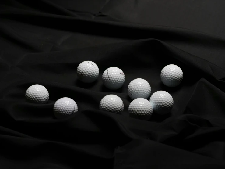 a bunch of golf balls on a black cloth, by László Balogh, unsplash, photorealism, white, decoration, product shoot, modeled