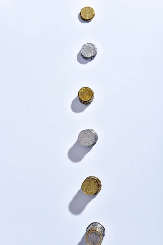 a row of coins sitting on top of a white surface, visual art, mid air shot, one contrasting small feature, product shot, 1 4 5 0