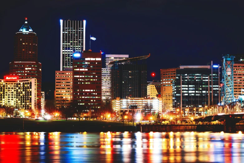 a view of a city at night from across the water, oregon, instagram picture, glass buildings, a colorful