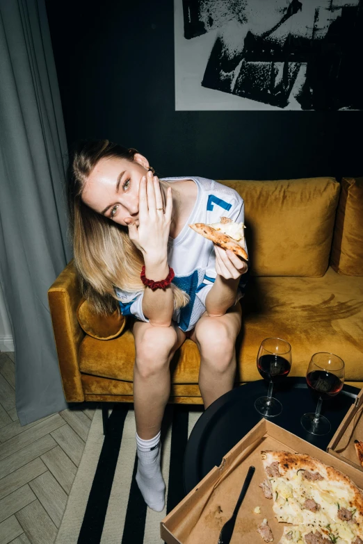 a woman sitting on a couch eating pizza, by Julia Pishtar, pexels contest winner, visual art, russian girlfriend, superbowl, his legs spread apart, instagram model