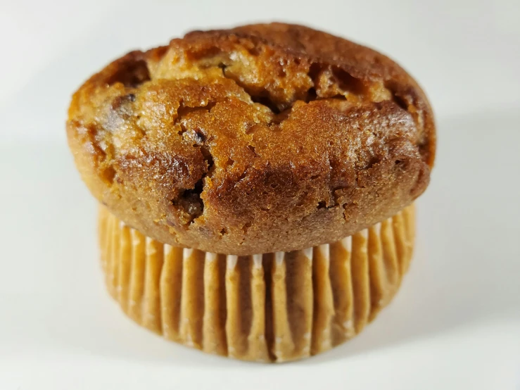 a close up of a muffin on a white surface, by Robbie Trevino, dessert, gopro photo, bakery, traditional medium