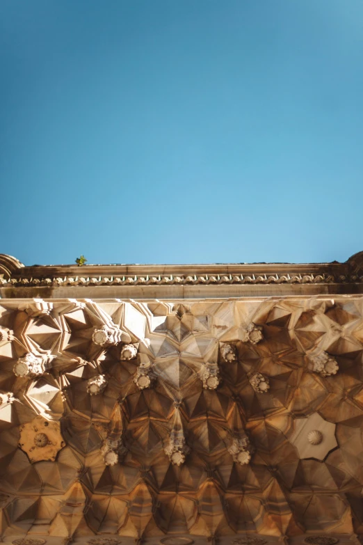 a man riding a skateboard up the side of a ramp, an abstract sculpture, inspired by Frederick Lord Leighton, trending on unsplash, baroque, intricate detailed roof, marrakech, view from below, shades of gold display naturally