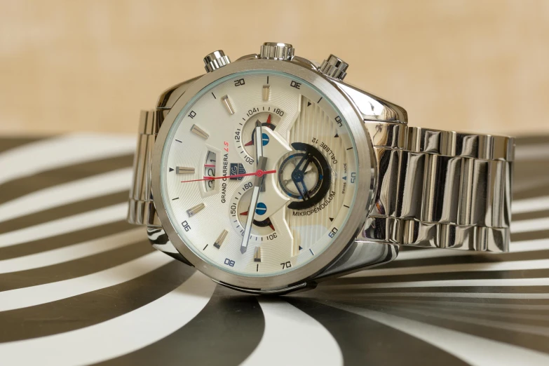 a close up of a watch on a table, inspired by Eugène Brands, unsplash, transformers movie style tech, silver，ivory, demur, formula 1