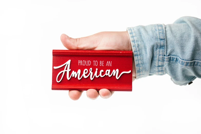 a person holding a sign that says proud to be an american, metallic red, product shot, multicoloured, detail shot