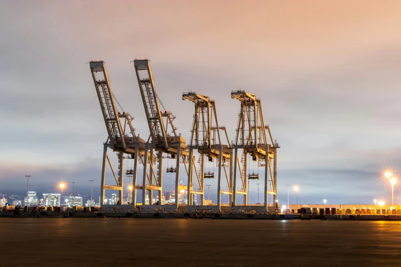 a group of cranes sitting next to each other, by Brad Holland, pexels contest winner, hyperrealism, in a sci-fi shipping port, california, national geography photography, tall structures