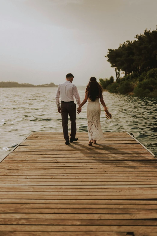 a man and a woman walking on a pier, a picture, pexels contest winner, bride and groom, summer lake setting, hispanic, about to step on you