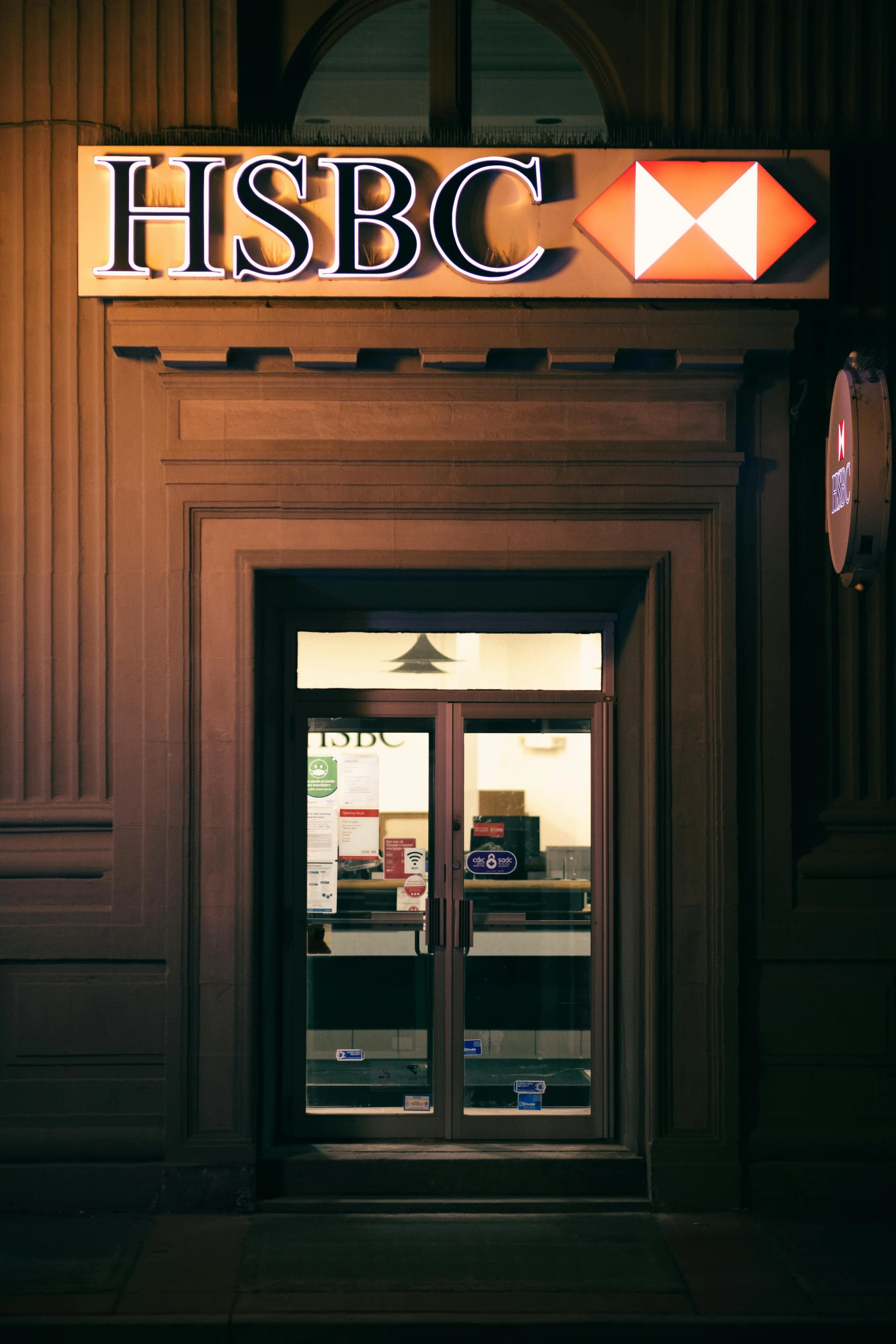 the entrance to a hsbc store lit up at night, renaissance, door to lab, best color graded, promo image, wooden banks