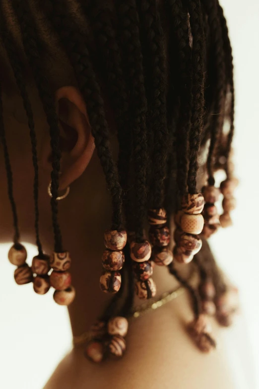 a close up of a woman with dreadlocks, by Nina Hamnett, beads, brown tones, patterned, ashteroth