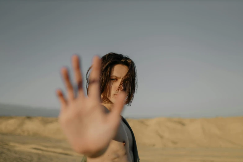 a woman holding her hand out in the desert, an album cover, unsplash, visual art, frank dillane as puck, non binary model, eleven/millie bobbie brown, photography of todd hido