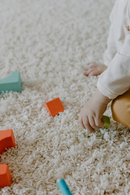 a baby sitting on the floor playing with blocks, inspired by Frederick Hammersley, pexels contest winner, moist brown carpet, lo - fi colors, square, animation