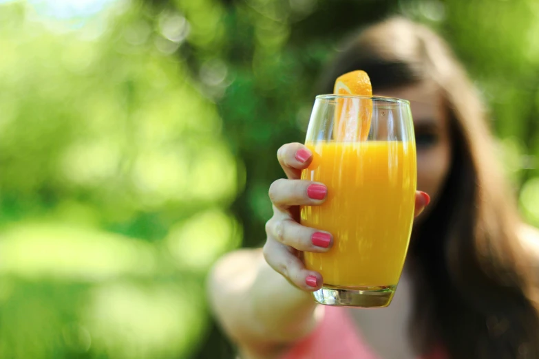 a woman holding a glass of orange juice, pexels, renaissance, springtime vibrancy, 🦩🪐🐞👩🏻🦳, moringa juice, thumbnail