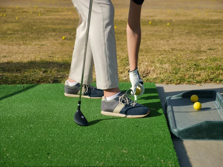 a man and a woman playing a game of golf, unsplash, realism, artificial limbs, whole shoe is in picture, rectangle, fake grass