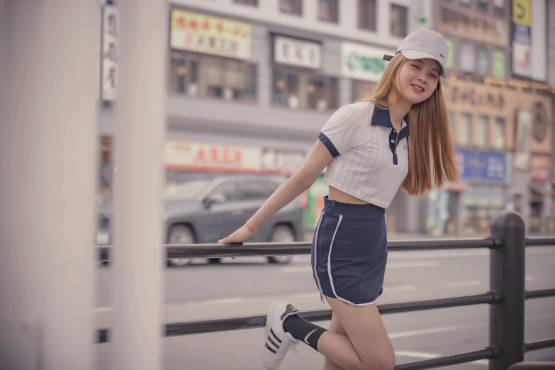 a woman that is standing on a rail, a colorized photo, inspired by Cheng Jiasui, pexels contest winner, realism, wearing a baseball cap, wearing crop top and miniskirt, street corner, cute kawaii girl