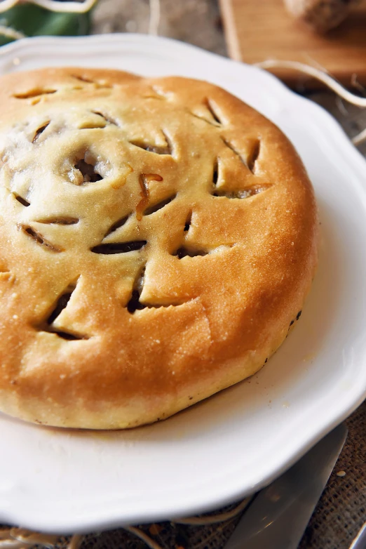 a pastry sitting on top of a white plate, inspired by Romano Vio, hurufiyya, gorget, pine, turkey, wales