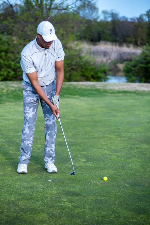 a man hitting a golf ball on a golf course, happening, wearing camo, riyahd cassiem, off - putting, grey