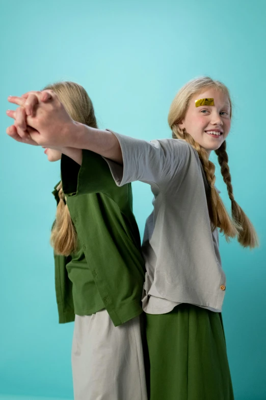 a couple of young girls standing next to each other, inspired by Kate Greenaway, unsplash, hurufiyya, greta thunberg as gollum, battle action pose, magical school student uniform, studio shoot