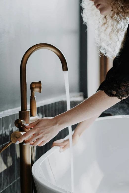 a woman washing her hands in a bathtub, trending on unsplash, renaissance, copper and brass, tall, low key light, elegant clean design