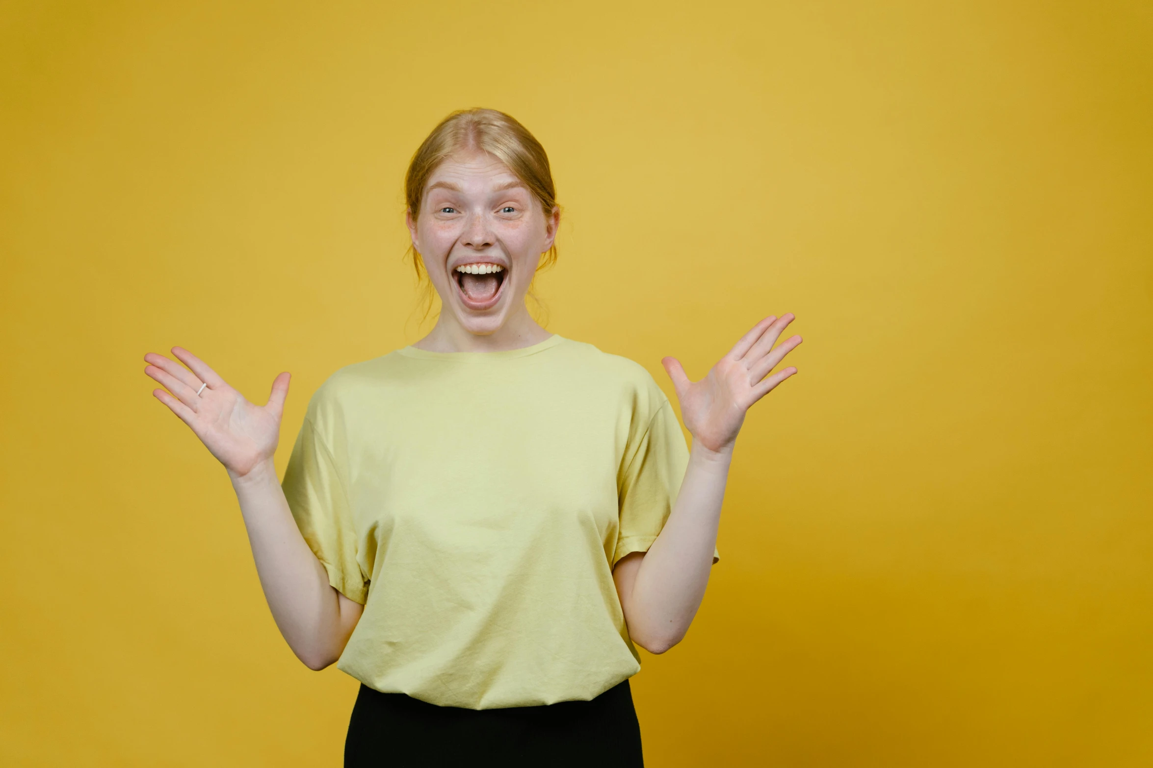 a woman making a funny face with her hands, pexels contest winner, wearing a modern yellow tshirt, 15081959 21121991 01012000 4k, excitement, pale - skinned