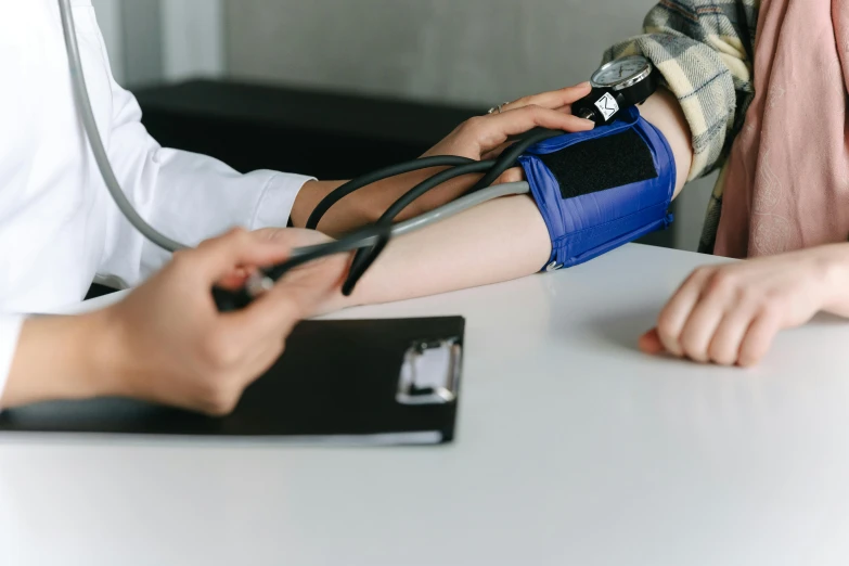 a doctor checking a patient's blood pressure with a stethoscope, by Emma Andijewska, pexels, hyperrealism, square, coloured, navy, small in size