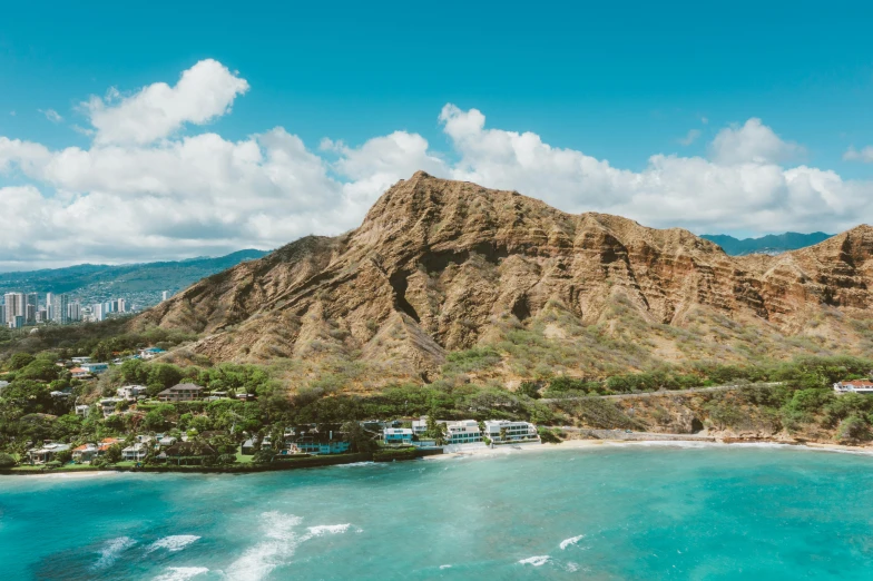 a beach with a mountain in the background, by Drew Tucker, pexels contest winner, aerial view of an ancient land, frank lloyd wright, hawaii, festivals