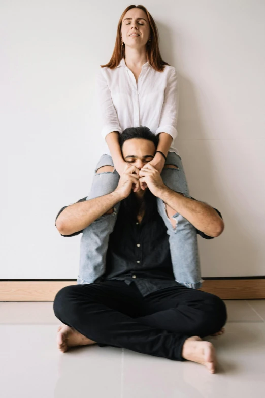 a man sitting on top of a woman on the floor, by Nina Hamnett, unsplash, speak no evil, symmetrical pose, plain background, cuddly