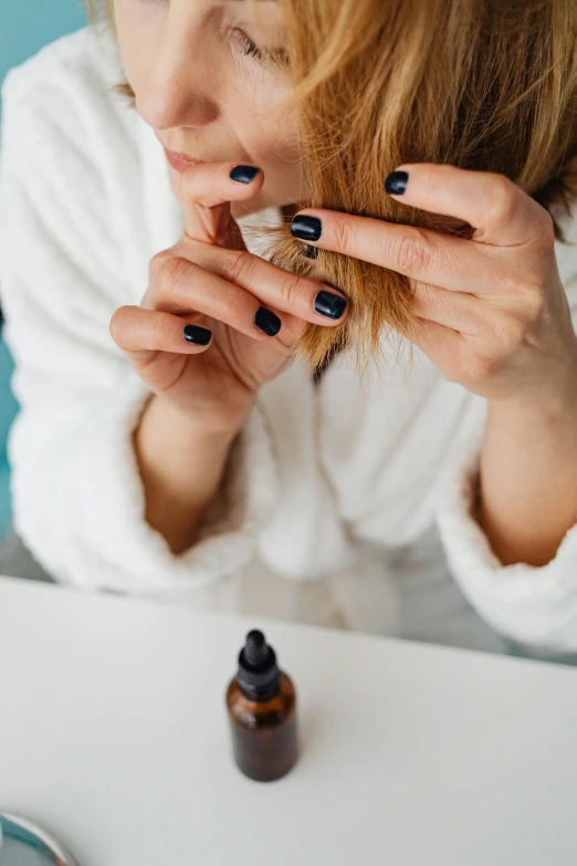 a woman in a bathrobe brushing her teeth, by Julia Pishtar, trending on pexels, renaissance, neat nails, black oil, indigo, thumbnail