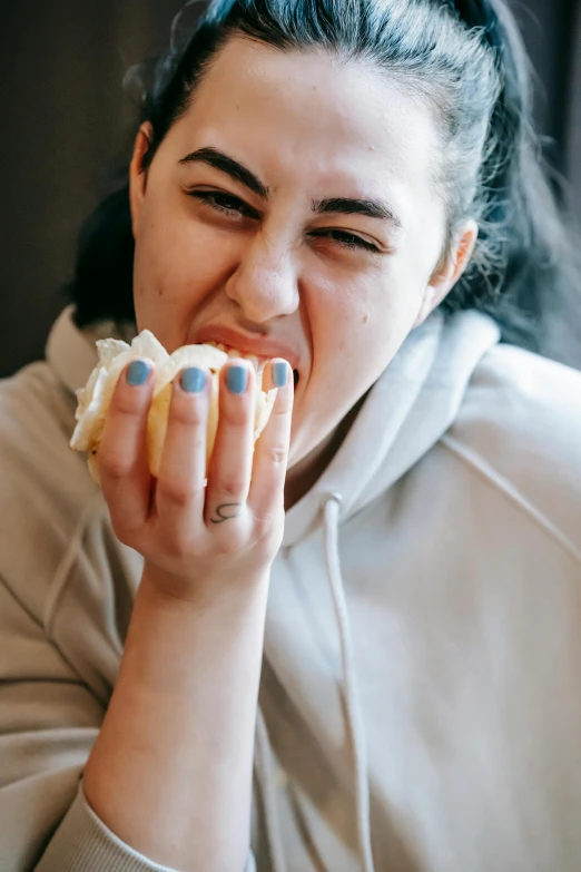 a woman sitting at a table eating a hot dog, inspired by Elsa Bleda, unsplash, renaissance, clenching teeth, square, bun, plus-sized