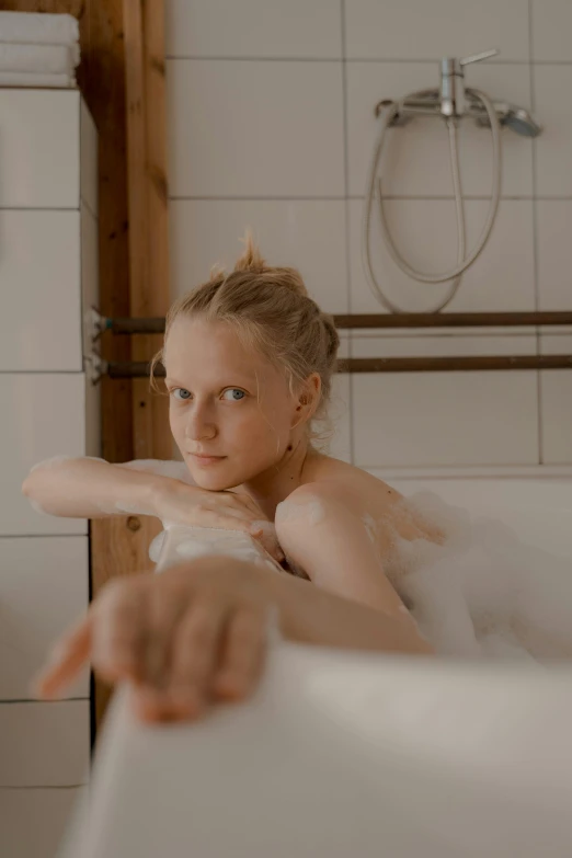 a woman taking a bath in a bathtub, by Anna Boch, unsplash, extremely pale blond hair, captured on canon eos r 6, gif, looking content