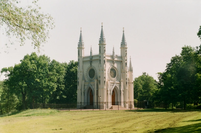 a large building sitting on top of a lush green field, an album cover, by Philip de Koninck, pexels contest winner, baroque, highgate cemetery, white, still from a wes anderson movie, alabaster gothic cathedral