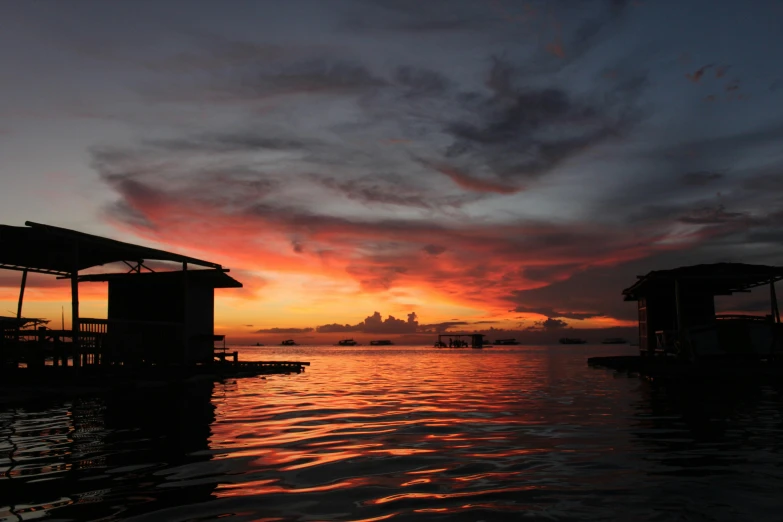 a couple of boats sitting on top of a body of water, a picture, at the sunset, philippines, slide show, multiple stories