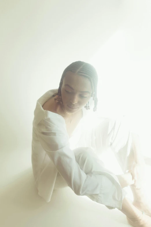 a woman sitting on top of a bed next to a window, an album cover, inspired by Elsa Bleda, unsplash, dressed in white robes, on a mannequin. studio lighting, doja cat, sun flare