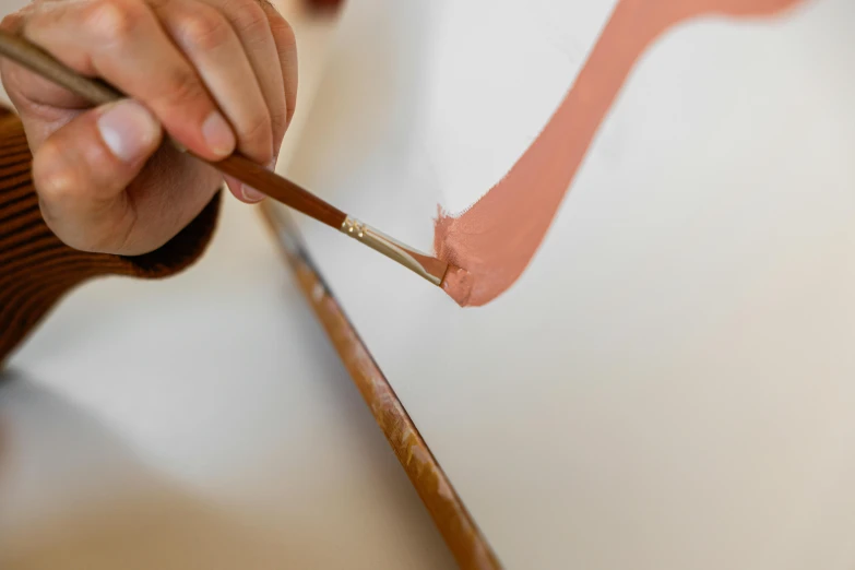 a person painting on a canvas with a brush, a photorealistic painting, inspired by Kyffin Williams, trending on pexels, blushing, holding a wooden staff, simple curvilinear watercolor, close-up photograph