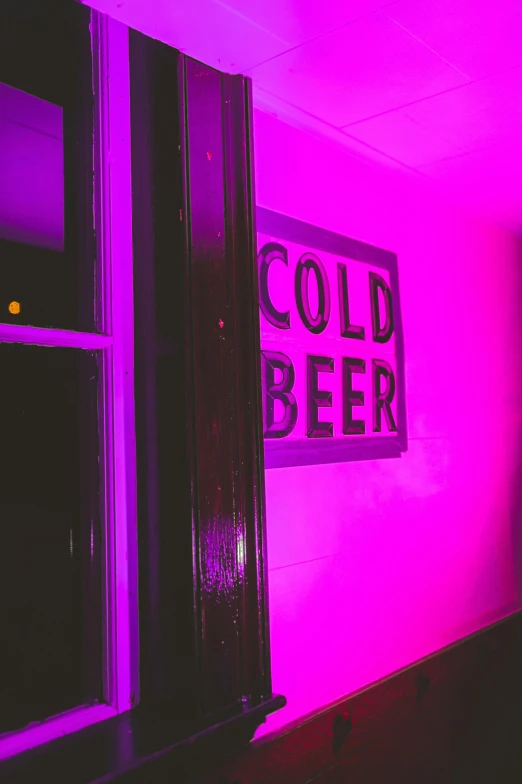 a sign that says cold beer in front of a window, inspired by Elsa Bleda, trending on unsplash, barely lit warm violet red light, stage at a club, pink door, low quality photo