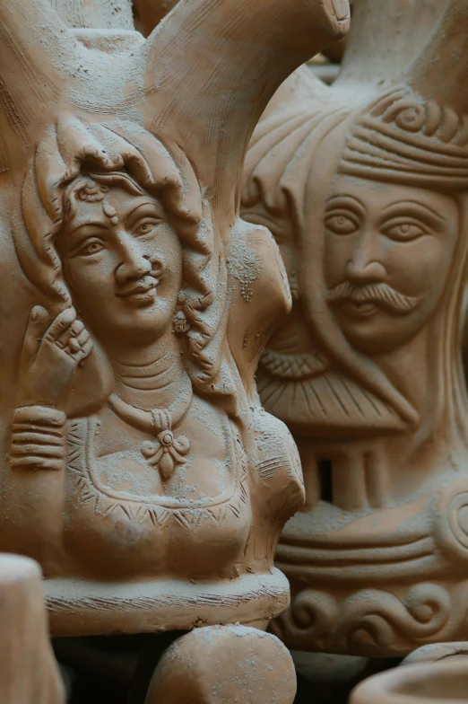 a group of clay figurines sitting next to each other, art nouveau, hindu aesthetic, closeup at the face, medium shot of two characters, made of clay