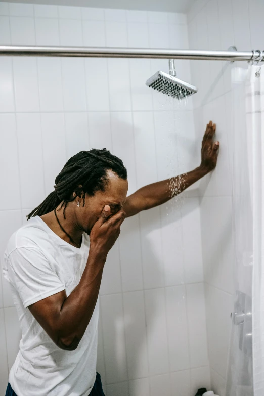a man brushing his teeth in a bathroom, an album cover, trending on pexels, dreadlocks, covered in water drops, head bowed slightly, african american