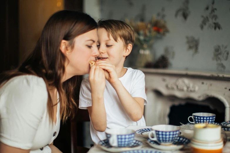 a woman and a child sitting at a table, by Emma Andijewska, pexels contest winner, licking, tea party, a handsome, 15081959 21121991 01012000 4k