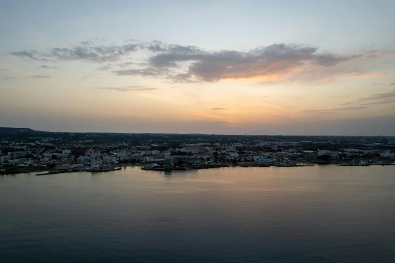 a large body of water with a sunset in the background, by Carey Morris, pexels contest winner, apulia, renaissance port city background, wide high angle view, overcast day