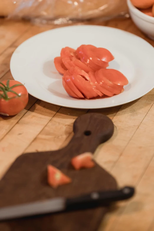 a cutting board topped with sliced tomatoes on top of a wooden table, sculptured, krakens, plated, award - winning