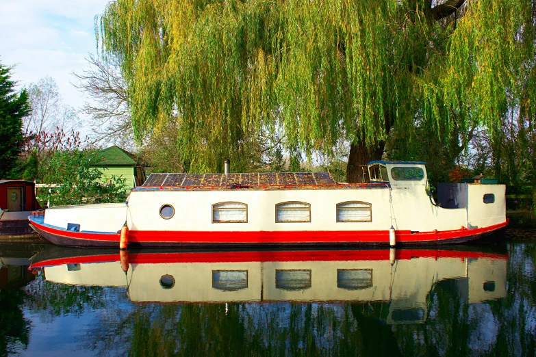 a boat sitting on top of a body of water, by Peter Prendergast, flickr, canals, willow trees, peter marlow photography, 2 0 0 0's photo