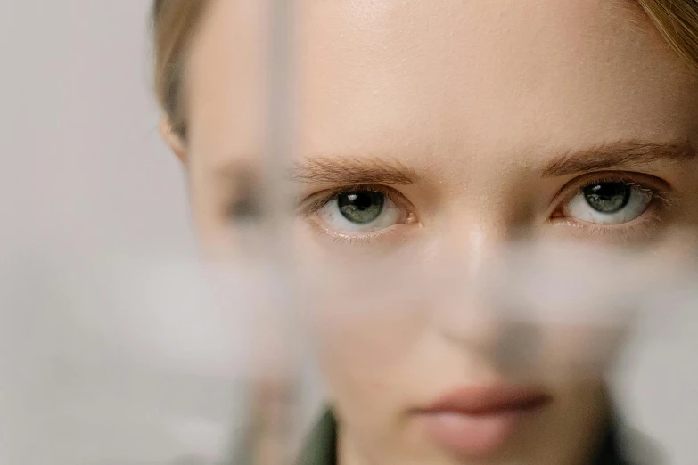 a close up of a woman looking at the camera, inspired by Anna Füssli, visual art, the woman is behind bars, transparent glass woman, eleven/millie bobbie brown, accurate green eyes