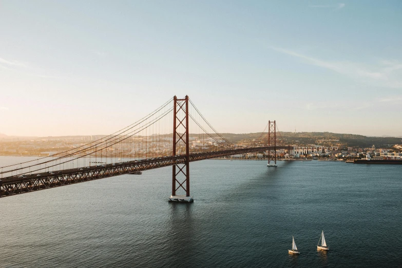 a large bridge over a body of water, pexels contest winner, lisbon, sailboats in the water, mies van der rohe, birdeye