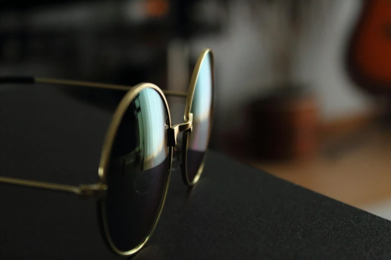 a pair of sunglasses sitting on top of a table, pexels contest winner, photorealism, wearing gold glasses, close-up shot taken from behind, sleek round shapes, shot with sony alpha