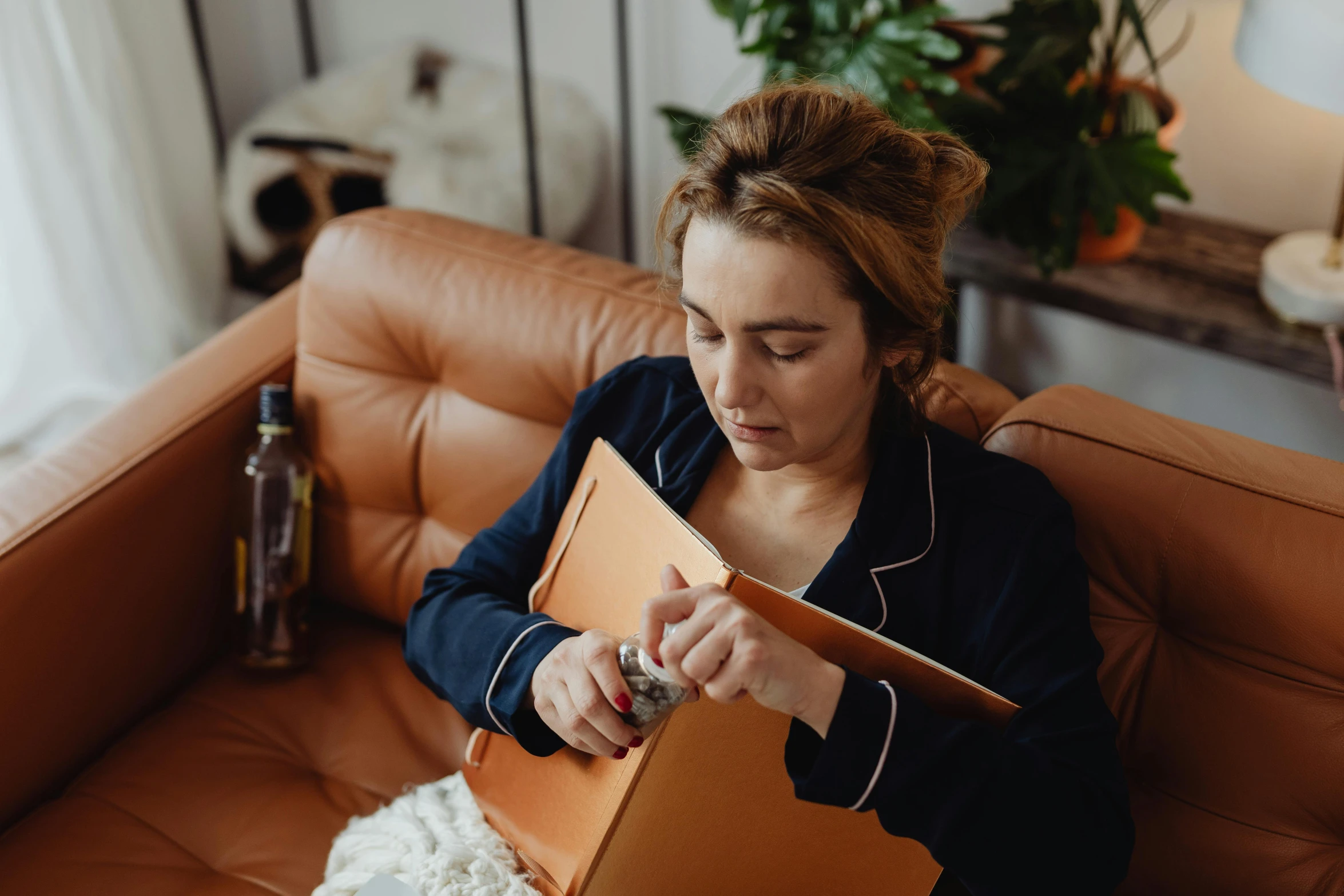 a woman sitting on a couch reading a book, by Julia Pishtar, holding a clipboard, amber, lena oxton, sleepy