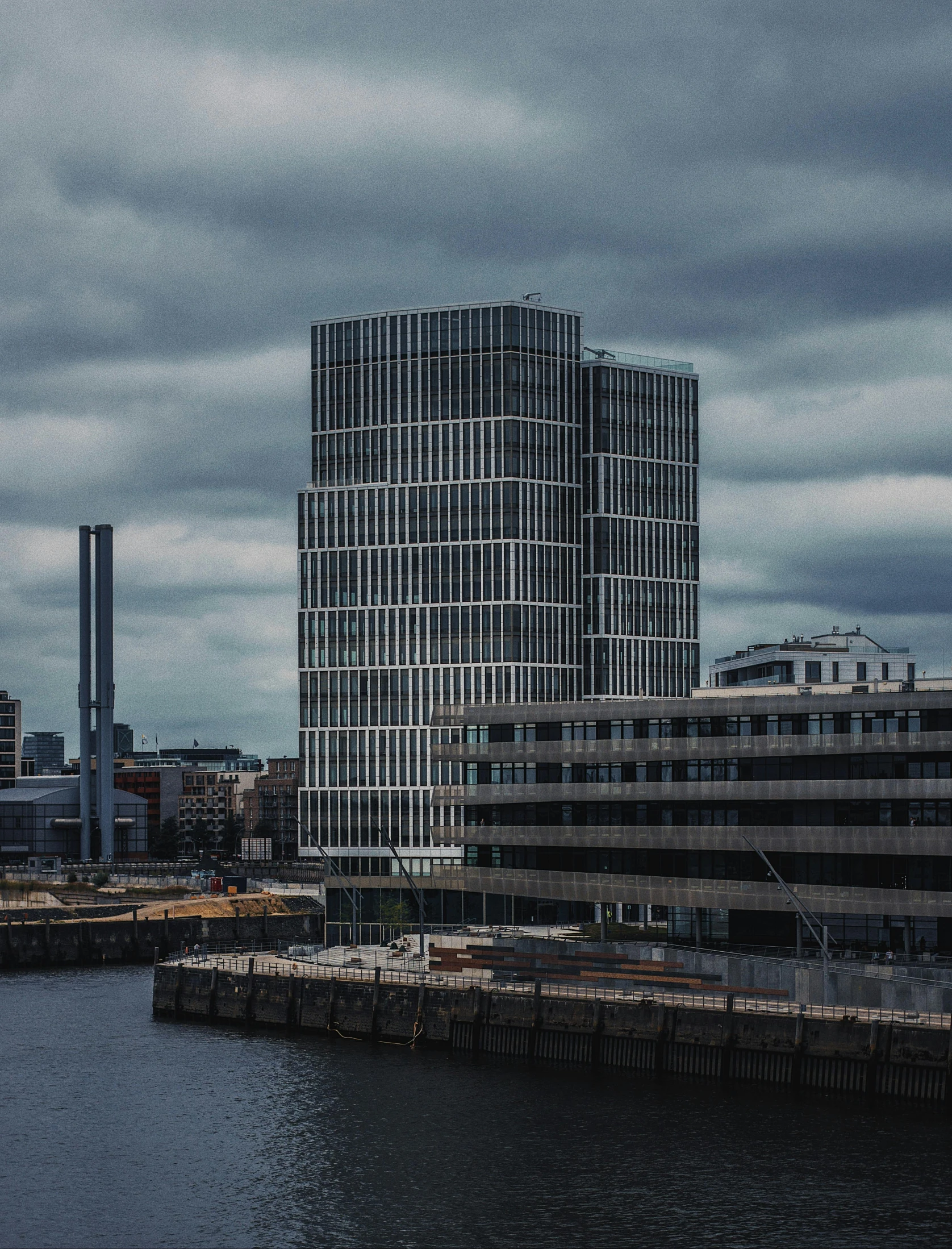 a large body of water next to a tall building, inspired by David Chipperfield, pexels contest winner, brutalism, paisley, thumbnail, jörmungandr, stacked image