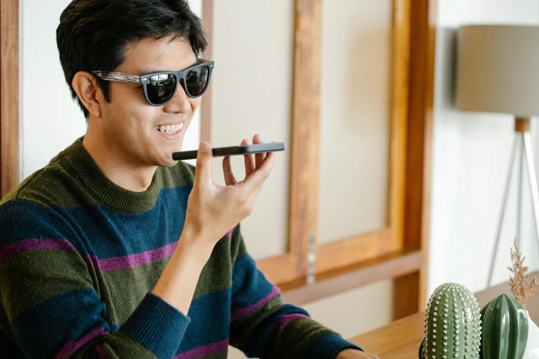 a man sitting at a table with a cell phone in his hand, trending on pexels, shin hanga, wearing shades, the straw is in his mouth, draw with wacom tablet, holding microphone