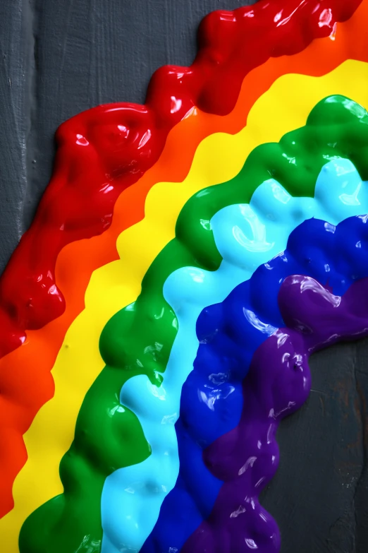 a rainbow cake sitting on top of a wooden table, an album cover, inspired by Lynda Benglis, trending on pexels, crayon art, wet clay, close-up from above, made of liquid, lesbian art