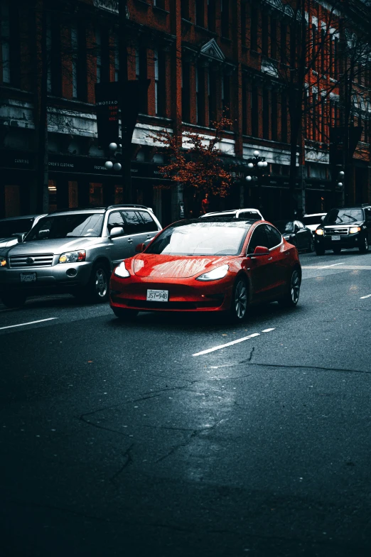 a red car driving down a street next to tall buildings, pexels contest winner, renaissance, tesla, on a sidewalk of vancouver, gif, headlights